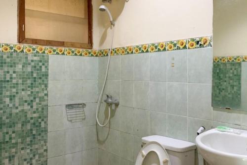 a bathroom with a shower and a toilet and a sink at Kemang Place near Lippo Mall Kemang Mitra RedDoorz in Jakarta