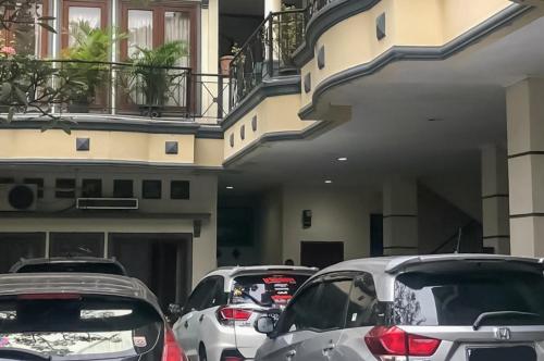een rij auto's geparkeerd voor een gebouw bij Kemang Place near Lippo Mall Kemang Mitra RedDoorz in Jakarta