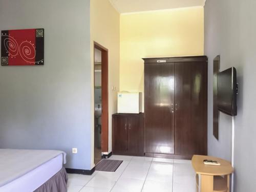 a room with a bed and a wooden door at Kemang Place near Lippo Mall Kemang Mitra RedDoorz in Jakarta