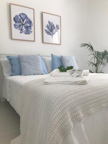 a bedroom with a white bed with blue pillows at Cocciu d’amuri in Terrasini