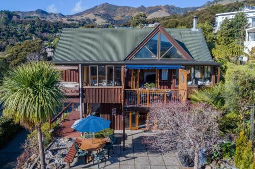 an aerial view of a house with mountains in the background at Pointers - Akaroa Holiday Home in Akaroa