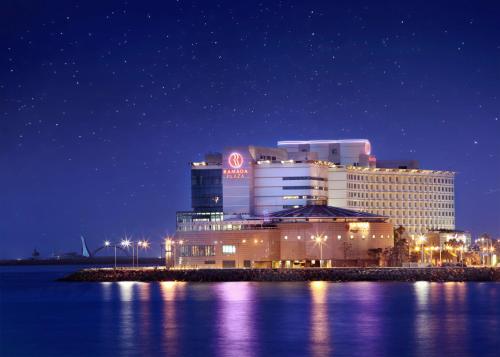 a large building with a large clock on it at Ramada Plaza by Wyndham Jeju Ocean Front in Jeju