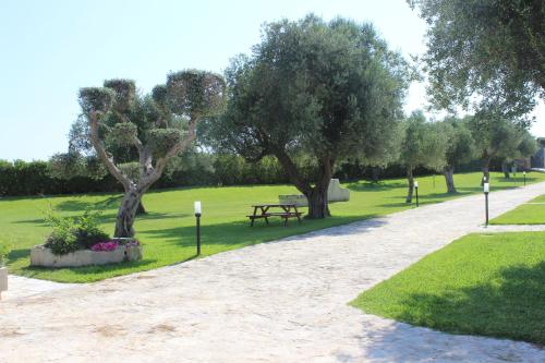 a park with a picnic table and trees and grass at Masseria Un Posto al Sole in Otranto
