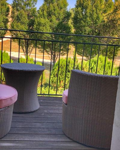 two wicker chairs and a table on a deck at Le Pré du Moulin - Maison Alonso - Hôtel & Restaurant in Sérignan-du-Comtat