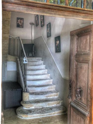 a stairway in a house with a wooden door at Le Pré du Moulin - Maison Alonso - Hôtel & Restaurant in Sérignan-du-Comtat
