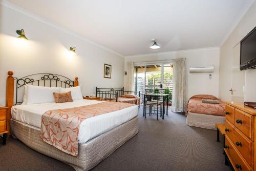 Nelsons of Bridgetown في بريدج تاون: غرفة نوم بسرير وطاولة وكراسي