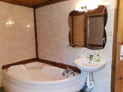 a bathroom with a tub and a sink and a toilet at Agroturystyka pod Pstragiem in Zawoja