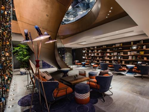 a lobby with a lot of chairs and books at Mercure Kyoto Station in Kyoto
