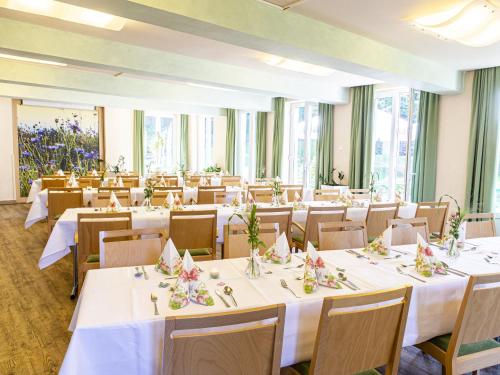 a room with tables and chairs with white tablecloths at SGV Jugendhof in Arnsberg