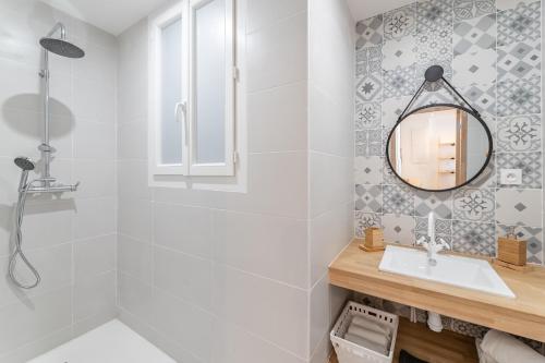 une salle de bain avec une douche, un lavabo et un miroir dans l'établissement Le Zòu par Dodo-a-Cassis, à Cassis