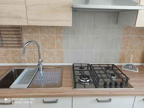 a kitchen counter with a sink and a stove at villa Beatrice in Serranova