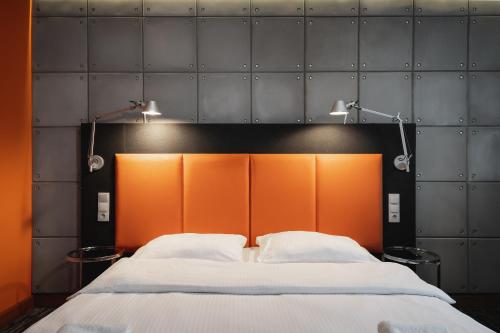 a bed with two pillows and two lights above it at Artis Loft Hotel in Radziejowice