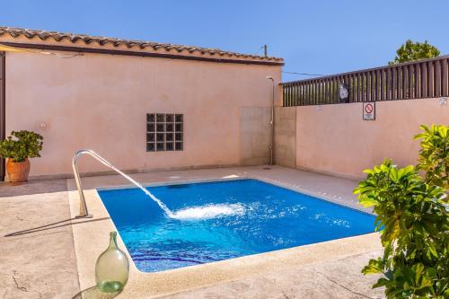 a swimming pool with a water fountain on a house at Cas Padrins de ses Tanques in Ariany