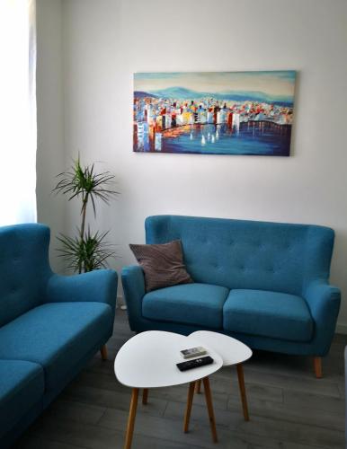 a living room with two blue couches and a table at Old Town in Pula
