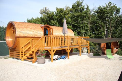 Casa de madera grande con terraza y sombrilla en L'Insolite Jurassienne, en Dompierre-sur-Mont