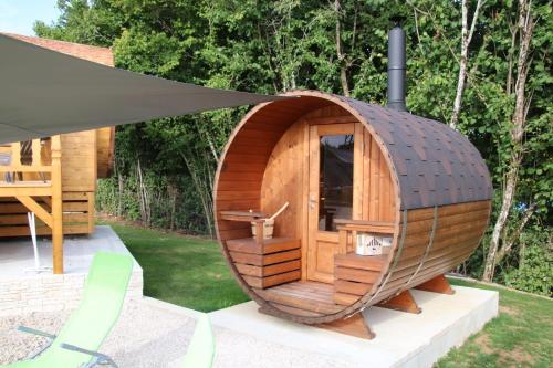 una pequeña casa de perros de madera en un patio en L'Insolite Jurassienne, en Dompierre-sur-Mont