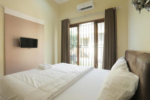 Un pat sau paturi într-o cameră la IDR Green Guest House Syariah Mitra RedDoorz
