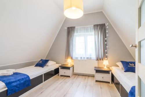 1 dormitorio en el ático con 2 camas y ventana en ApartamentyGdanske EU - Golden, en Gdansk