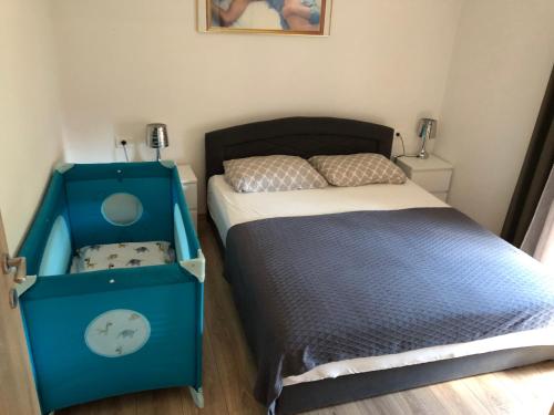 een kleine slaapkamer met een blauw bed en een wieg bij Apartment Petrovic Medulin in Medulin