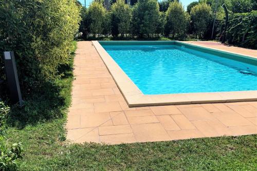 a swimming pool in a yard with a brick walkway at Apartment Charme and Relax with Garden and Swimming Pool in Desenzano del Garda