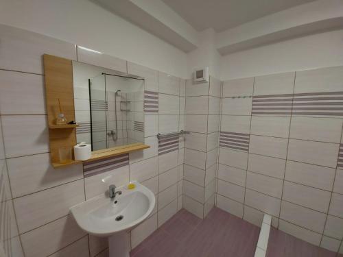 a white bathroom with a sink and a mirror at Didy Residence in Eforie Nord