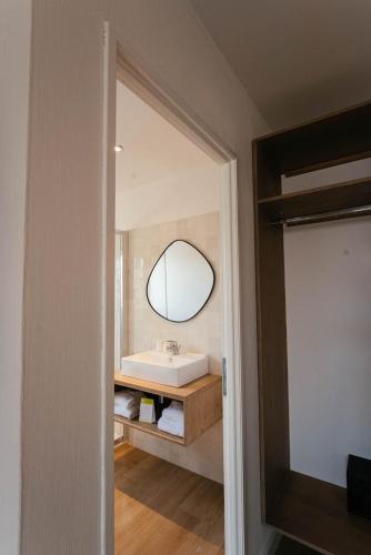 a bathroom with a sink and a mirror at Hôtel Casa Marina in Saintes-Maries-de-la-Mer