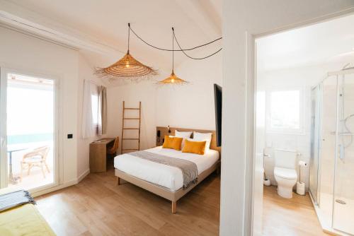 a bedroom with a bed with orange pillows and a ladder at Hôtel Casa Marina in Saintes-Maries-de-la-Mer