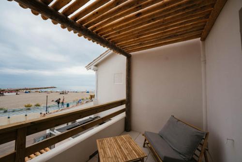 a balcony with a table and a view of the beach at Hôtel Casa Marina in Saintes-Maries-de-la-Mer