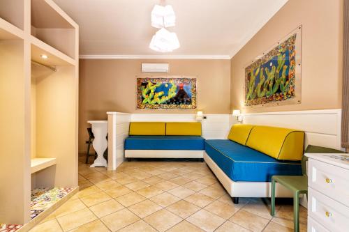 sala de estar con 2 sofás azules y amarillos en Residence Hotel La Giara en Lipari