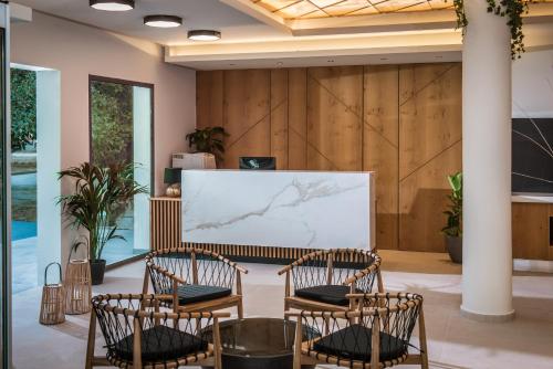 una stanza con tre sedie e uno schermo di proiezione di Malena Hotel & Suites - Adults Only by Omilos Hotels ad Amoudara Herakliou