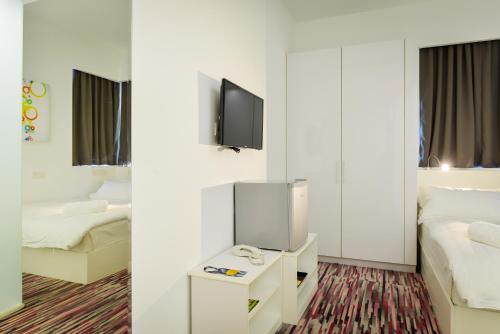 a hotel room with two beds and a tv at Pegasus Hotel Shah Alam in Shah Alam