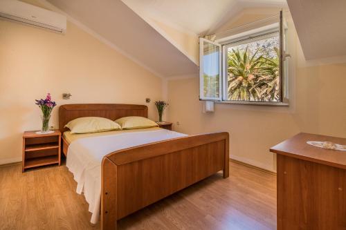 a bedroom with a bed and a window at Colonia Apartments in Orebić