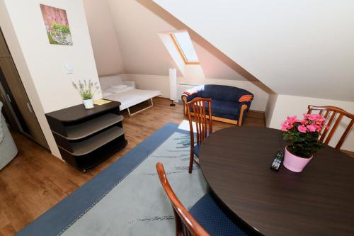 ein Wohnzimmer mit einem Tisch und Stühlen in der Unterkunft Ezüsthíd Hotel in Veszprém