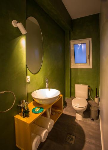 a green bathroom with a sink and a toilet at Koukounari Living Spaces in Preveza