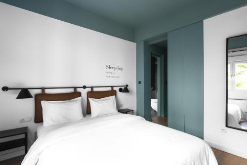 una camera da letto con un grande letto bianco e una finestra di Breen, Nilie Hospitality MGMT a Salonicco