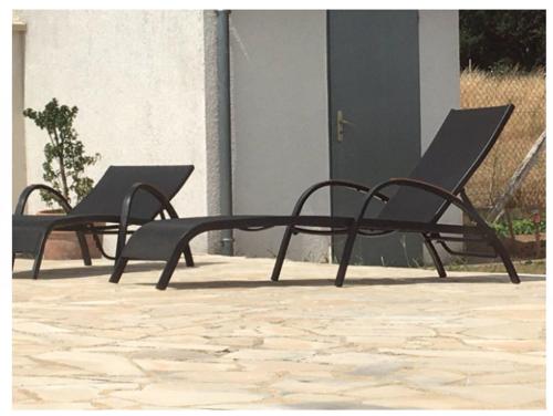 two black chairs sitting on a patio at maison blanche piscine et petit déjeuner in Châtellerault