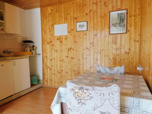 ein Schlafzimmer mit einem Bett in einer Holzwand in der Unterkunft Apartments Neno in Korčula