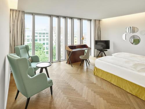 a hotel room with a bed and a desk and chairs at MAXX by Steigenberger Vienna in Vienna