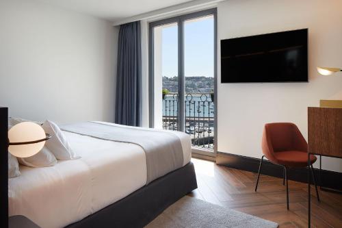 a hotel room with a large bed and a large window at Hotel SANSEbay in San Sebastián