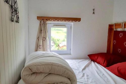ein Schlafzimmer mit einem Bett und einem Fenster in der Unterkunft Les 2 alpes, charmant et authentique 4-6 personnes in Mont-de-Lans
