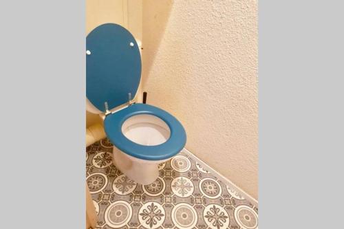 ein blaues WC mit blauem Sitz im Bad in der Unterkunft Les 2 alpes, charmant et authentique 4-6 personnes in Mont-de-Lans
