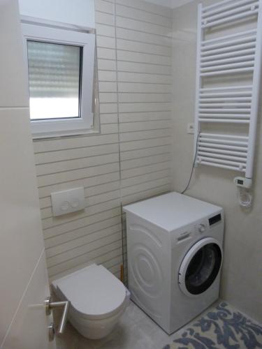een badkamer met een wasmachine en een toilet bij Apartman Pajo in Primošten