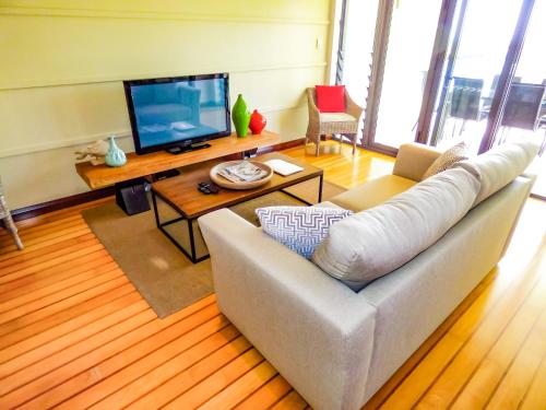 a living room filled with furniture and a tv at Boathouse Port of Airlie in Airlie Beach