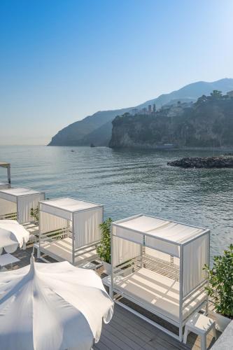 a group of white tents on a dock next to the water at Hotel Mary in Vico Equense