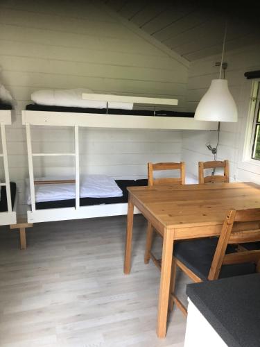a dining room with a table and a bunk bed at Lohals camping in Tranekær