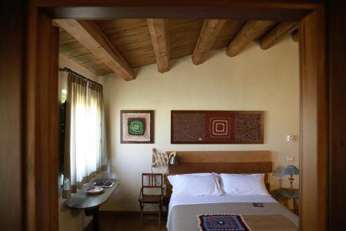 una camera con letto, tavolo e scrivania di Resort Fontes Episcopi ad Aragona