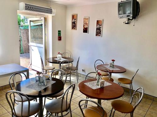 restauracja ze stołami i krzesłami oraz telewizorem w obiekcie Pokoje Hotelowe Norbit w mieście Grodzisk Mazowiecki