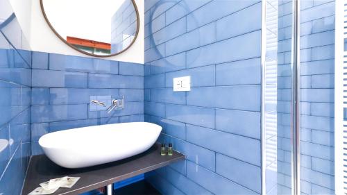 ein blau gefliestes Bad mit einem Waschbecken und einem Spiegel in der Unterkunft Italianway - Crosa dell'Oro 20 in Santa Margherita Ligure