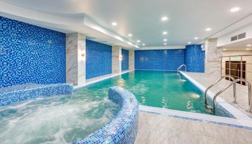 ウファにあるBashkiria Hotelの青い壁のホテルのプール、スイミングプールを提供しています。
