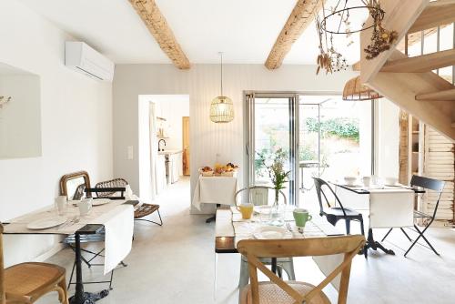 a dining room with white tables and chairs at Maison 1634 - Centre historique, parking, petit-dejeuner compris, climatisation, piscine in Pézenas